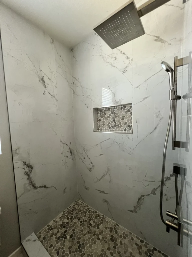 Walk-in shower with marble-look walls, a rain head and a pebble floor, Corona Hills