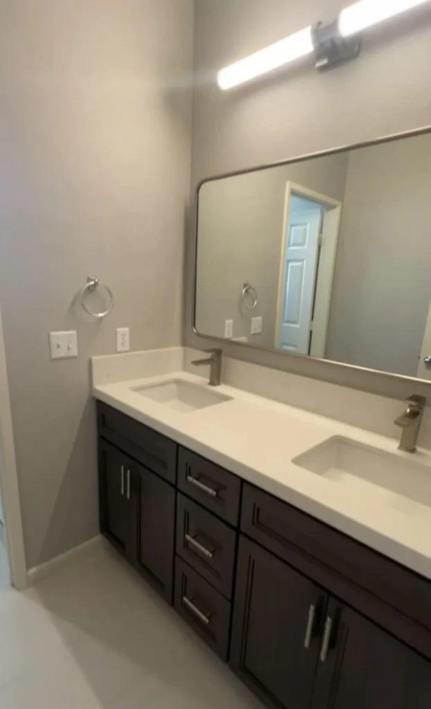 Double vanity with dark cabinets and a framed mirror, Corona Hills