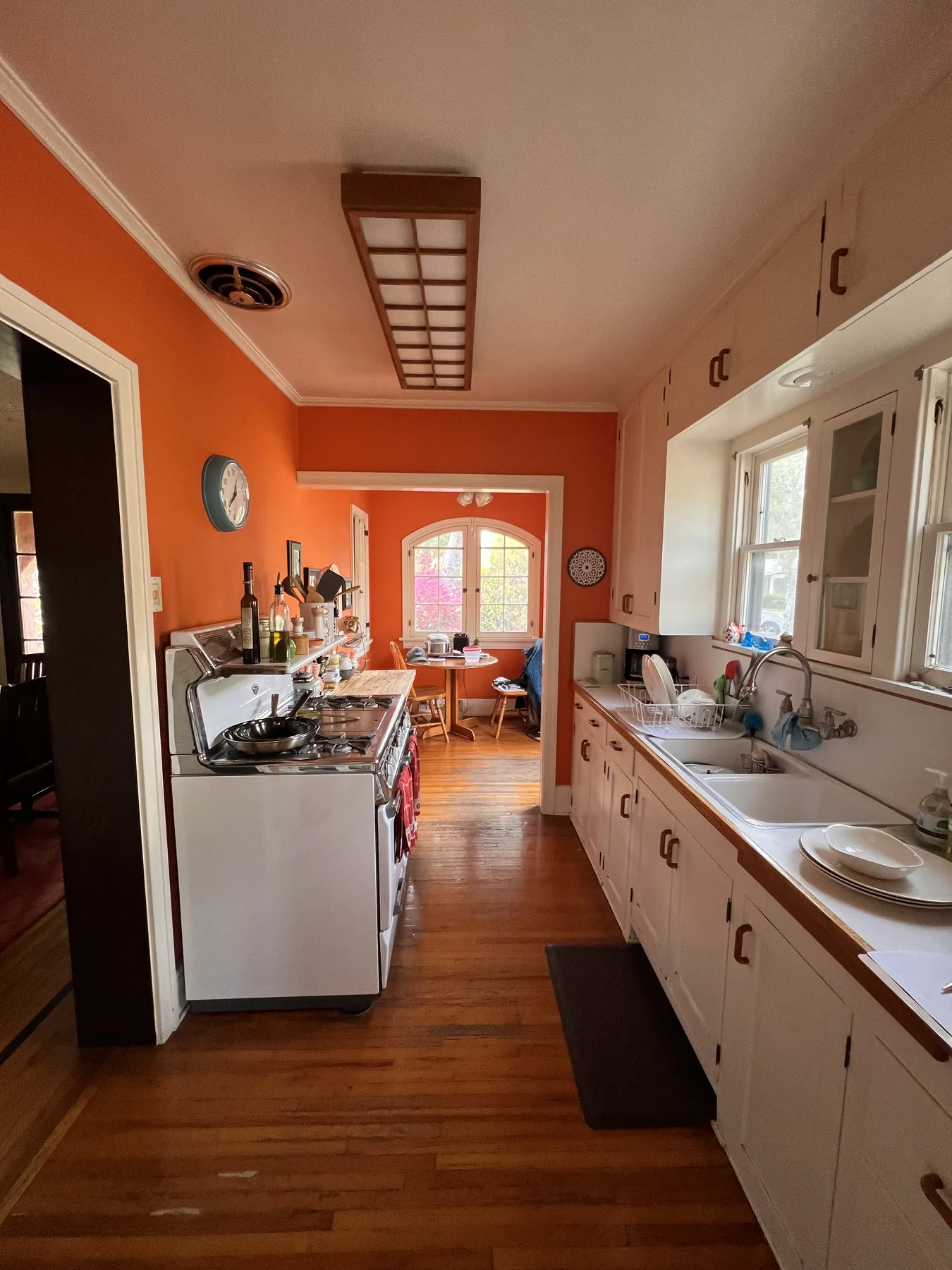 The Santa Ana kitchen before the remodel, with orange walls and the original cabinets