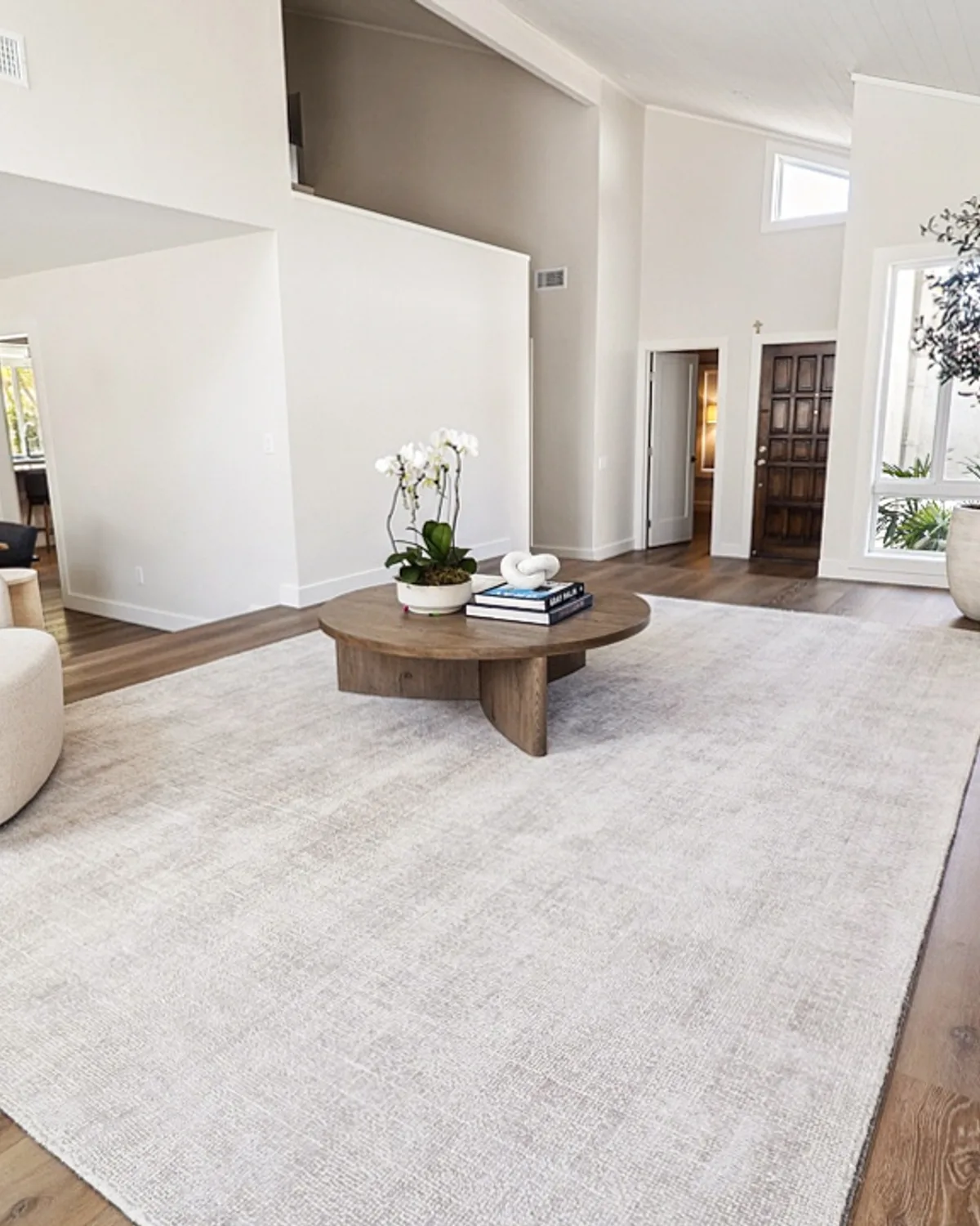 Open living room remodeled by Casa Renovations, with a vaulted ceiling and wide plank flooring